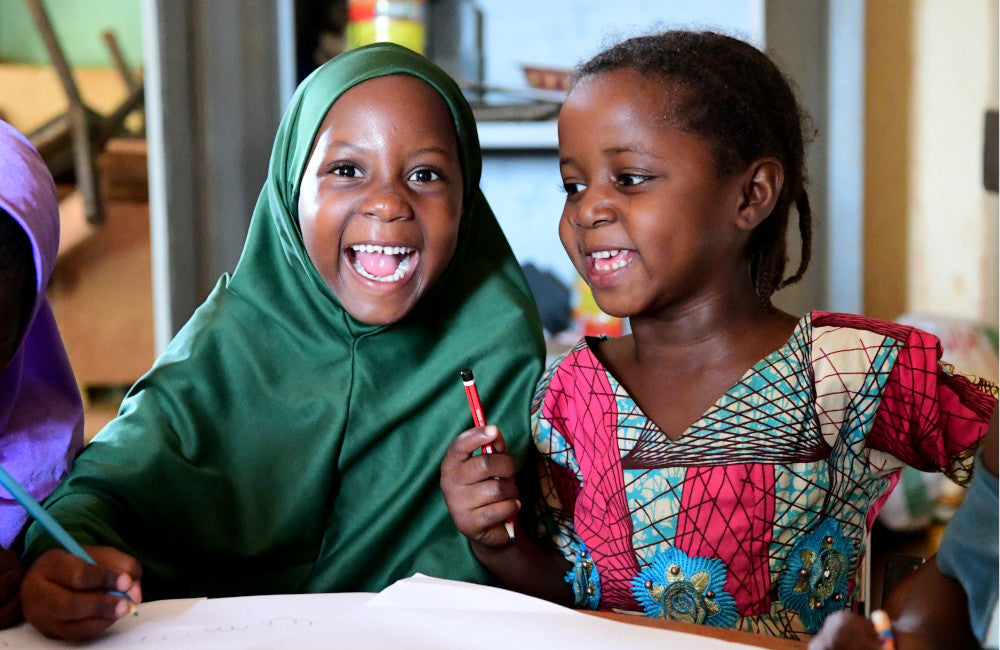 Girls writing in school © UNICEF/UN0443455/Dejongh