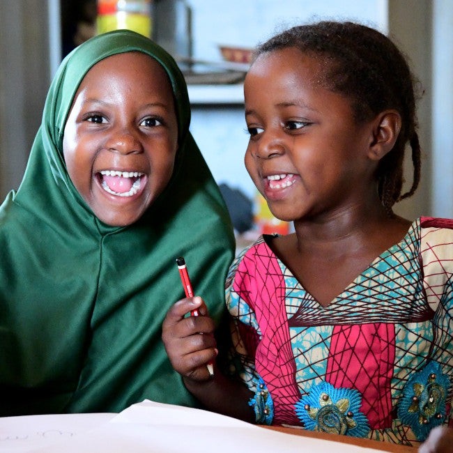 Smiling children enjoying pencils 