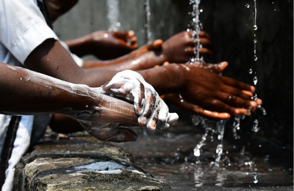 People wash their hands with soap under running water © UNICEF/UN0507487/Dejongh
