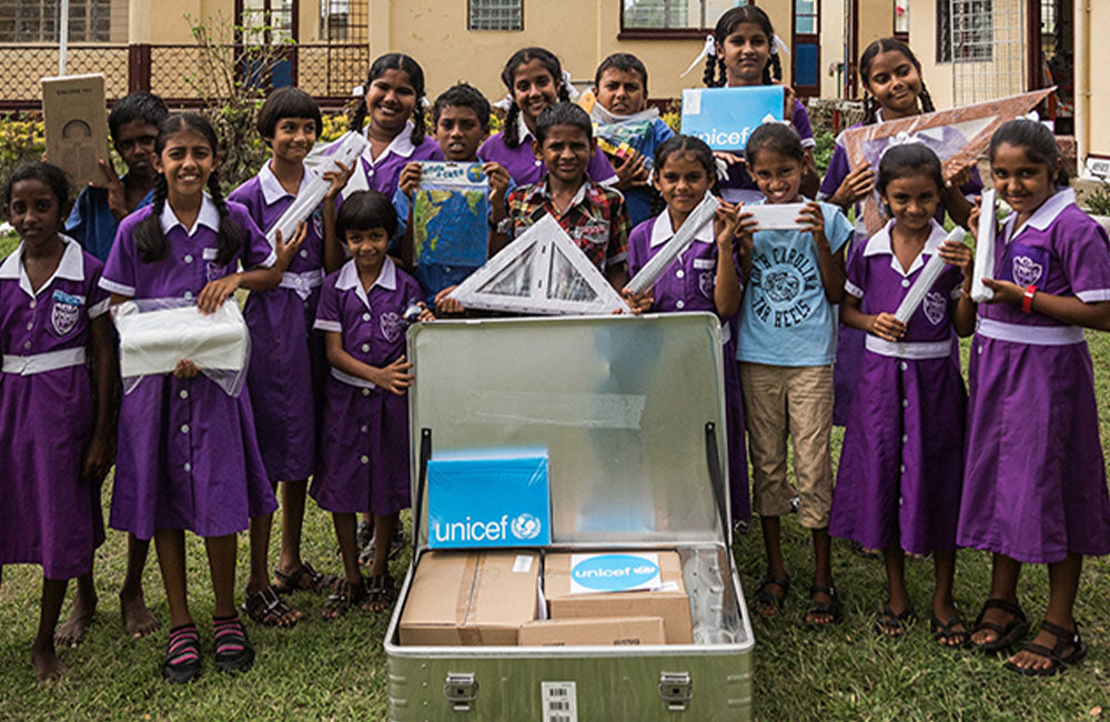 School children holding items from their school in a box © UNICEF/2016/Sokhin