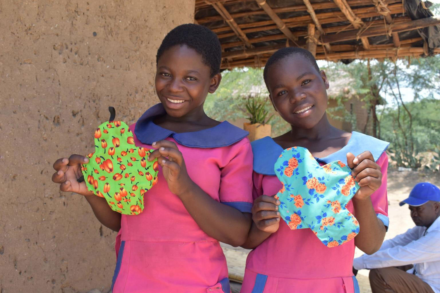 Two girls holding colourful feminine hygiene products. © UNICEF/UNI311742/