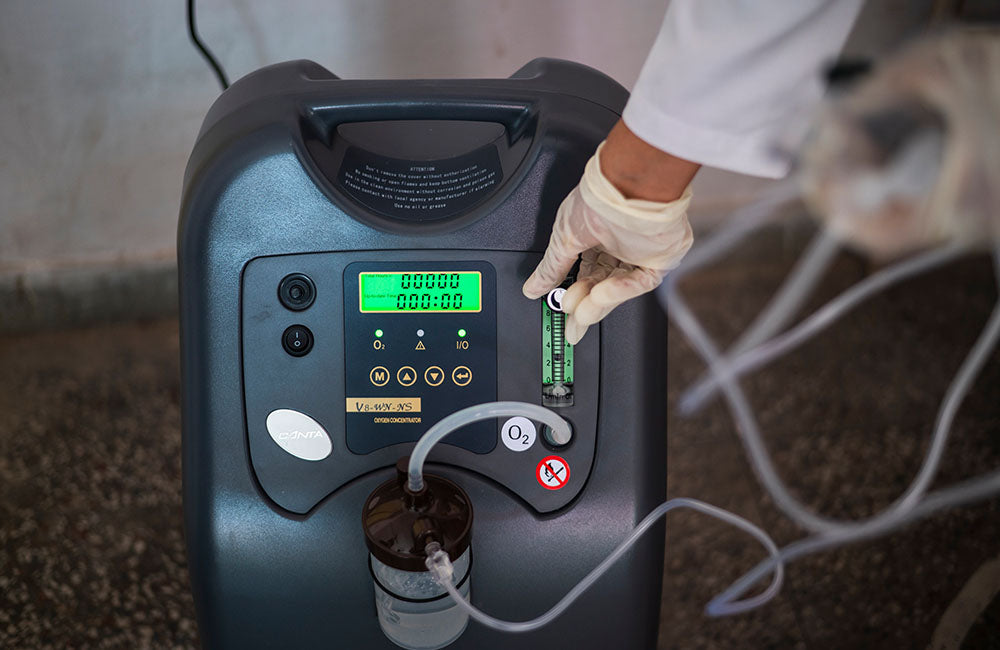 An oxygen concentrator machine is adjusted. © UNICEF/UN0467242/ Bhardwaj